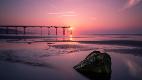 Majestic Pink Sunset Over Serene Pier wallpaper