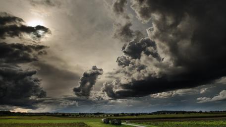 Stormy Skies Over Verdant Fields wallpaper