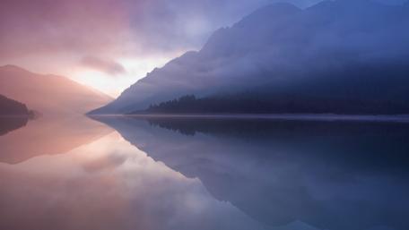 Misty Mountains Reflected in Serene Lake Waters wallpaper