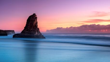 Serene Sunset Over Sea Stack Beach wallpaper