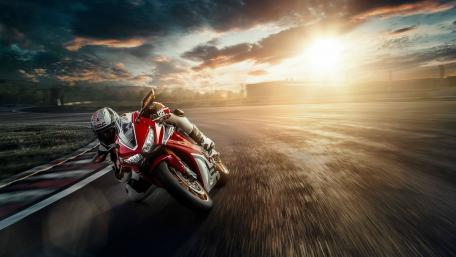 Dynamic Motorcycle Racing Moment in Sunset Light wallpaper