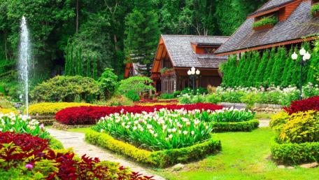 Spring Cottage Surrounded by Vibrant Gardens and Nature's Beauty wallpaper