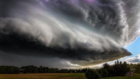 Dramatic Storm Clouds Over Grassland wallpaper
