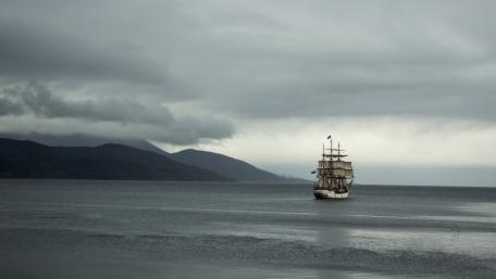 Sailing Ship Amidst Grey Waters and Clouds wallpaper