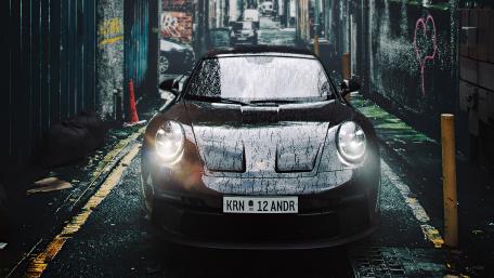 Sleek Porsche 911 in Rainy Alley Scene wallpaper
