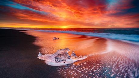 Burning Sky over Icy Shoreline at Sunset wallpaper