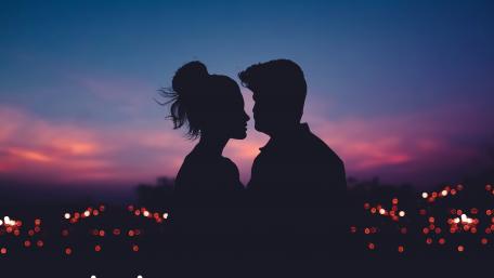 Silhouetted Lovers Embrace at Dusk wallpaper