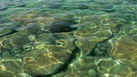 Serene Clear Water Over Rocks wallpaper