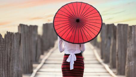 Burmese woman with a bagan  umbrella on rustic bridge wallpaper
