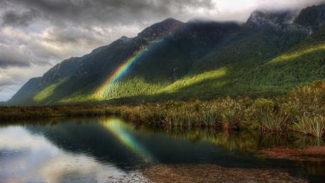 Serene Lake with Mountain Reflection Under Rainbow wallpaper