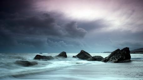 Stormy Beach Waves Under Dark Skies wallpaper