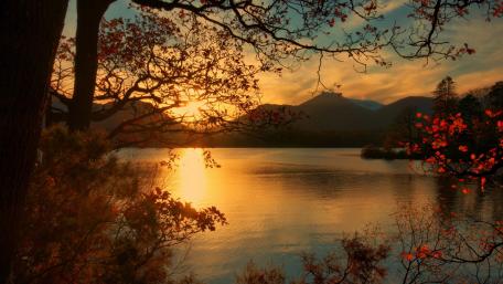 Golden Autumn Sunset Over Tranquil Lake Waters wallpaper