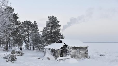 Cozy Winter Shack Amidst Snowy Landscape wallpaper