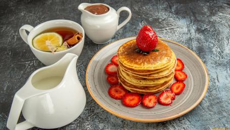 Delicious Pancakes with Fresh Strawberries and Tea Treats wallpaper