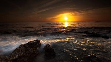 Serene Sunset Over Calm Sea Waves wallpaper