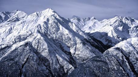 Majestic Snow-Capped Peaks Under a Serene Sky wallpaper