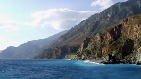 Majestic Mountains Overlooking Serene Sea Waves wallpaper