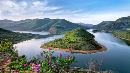 Serene River Bend Surrounded by Majestic Mountains wallpaper
