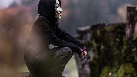 Masked Figure in Nature's Embrace wallpaper