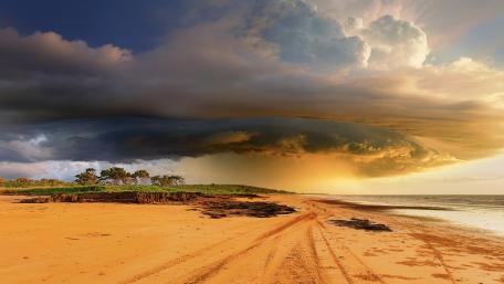 Majestic Stormy Skies Over Tranquil Beach wallpaper