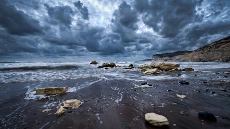 Dramatic Shoreline Under Cloudy Skies wallpaper