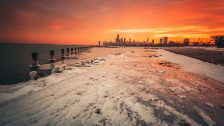 Vibrant Sunset Over Frozen Beach Cityscape wallpaper