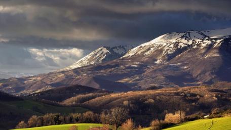 Majestic Snow-Capped Peaks Under Dramatic Skies wallpaper
