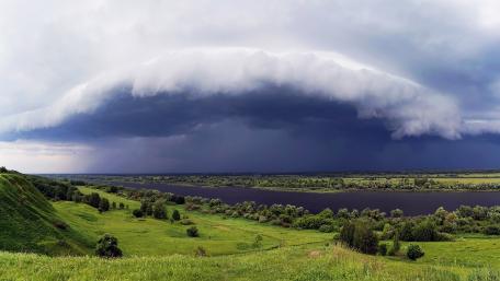 Majestic Rainclouds Over Serene River Landscape wallpaper