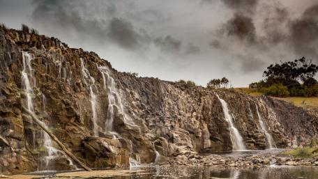 Majestic Waterfalls Cascading Over Rocky Cliffs wallpaper