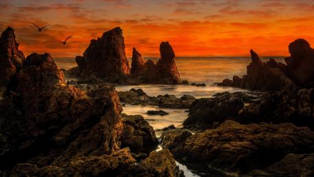 Majestic Sunset Over Rocky Ocean Shoreline wallpaper