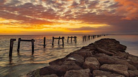 Serene Sunset Over Pier and Breakwater wallpaper