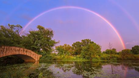 Serene Pond with Rainbow Over Stone Bridge wallpaper