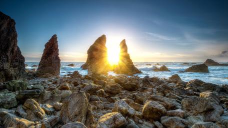 Majestic Sunset Over Rocky Shoreline wallpaper