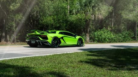 Vibrant Lamborghini Aventador SVJ on a Scenic Road wallpaper