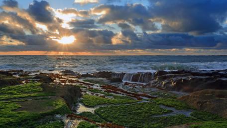 Serene Sunset Over Rocky Seashore wallpaper