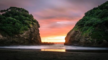 Serene Sunset Between Rocky Cliffs Over the Sea wallpaper
