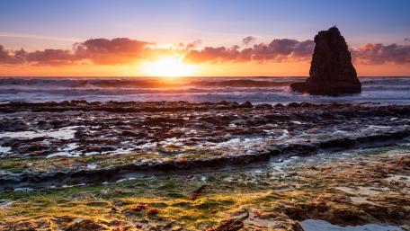 Serene Sunset Over Ocean Waves and Sea Stack wallpaper