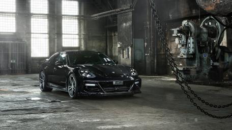 Sleek Black Porsche Panamera in Industrial Setting wallpaper
