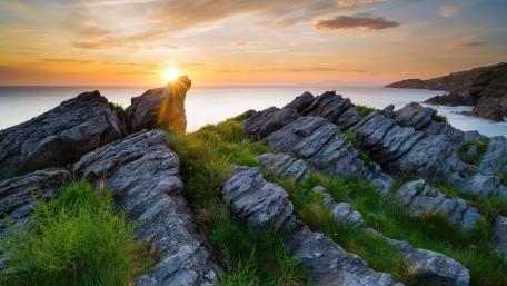 Serene Sunset Over Rocky Shoreline wallpaper