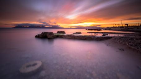 Serene Sunset Over Tranquil Sea and Shoreline wallpaper