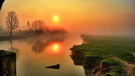 Serene Sunset Over a Foggy River Scene wallpaper