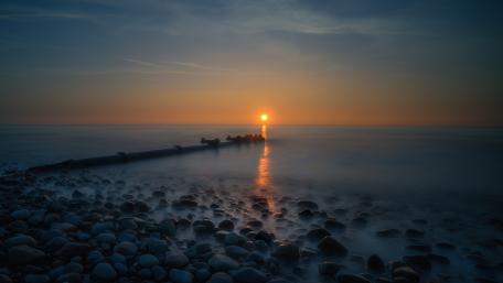 Serene Sunset Over the Breakwater Shoreline wallpaper