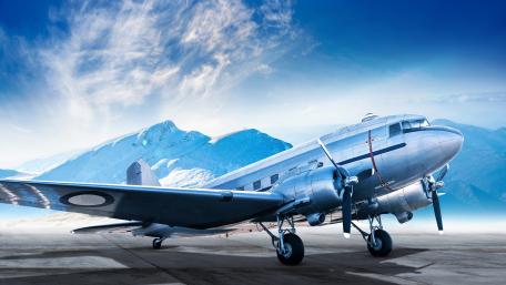 Vintage Airplane Against Majestic Mountains in 4K Resolution wallpaper