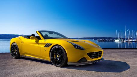 Dreamy Yellow Sports Car Under Clear Blue Skies wallpaper