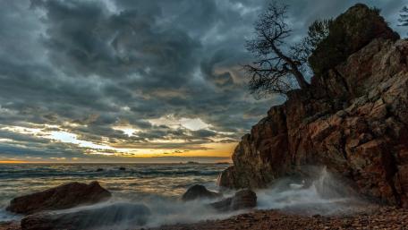 Serene Coastal Dusk Scene Amidst Dramatic Clouds wallpaper