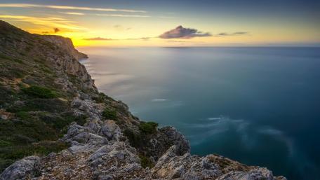 Serene Coastal Sunset Over Majestic Cliffs wallpaper