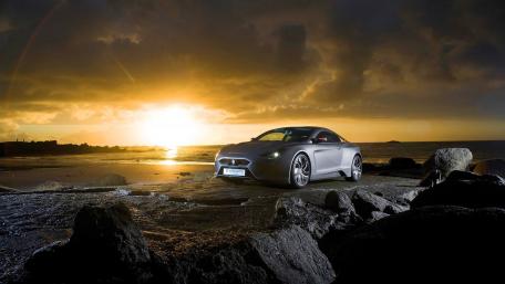 Sleek Car Against a Stunning Sunset View wallpaper