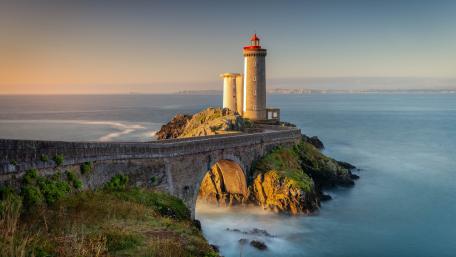Majestic Lighthouse Overlooking Serene Waters wallpaper