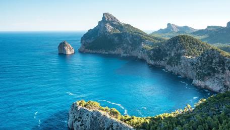 Serene Coastal View of Majestic Mountains and Blue Waters wallpaper