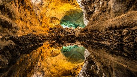 Mystical Cave Reflection in Nature's Embrace wallpaper